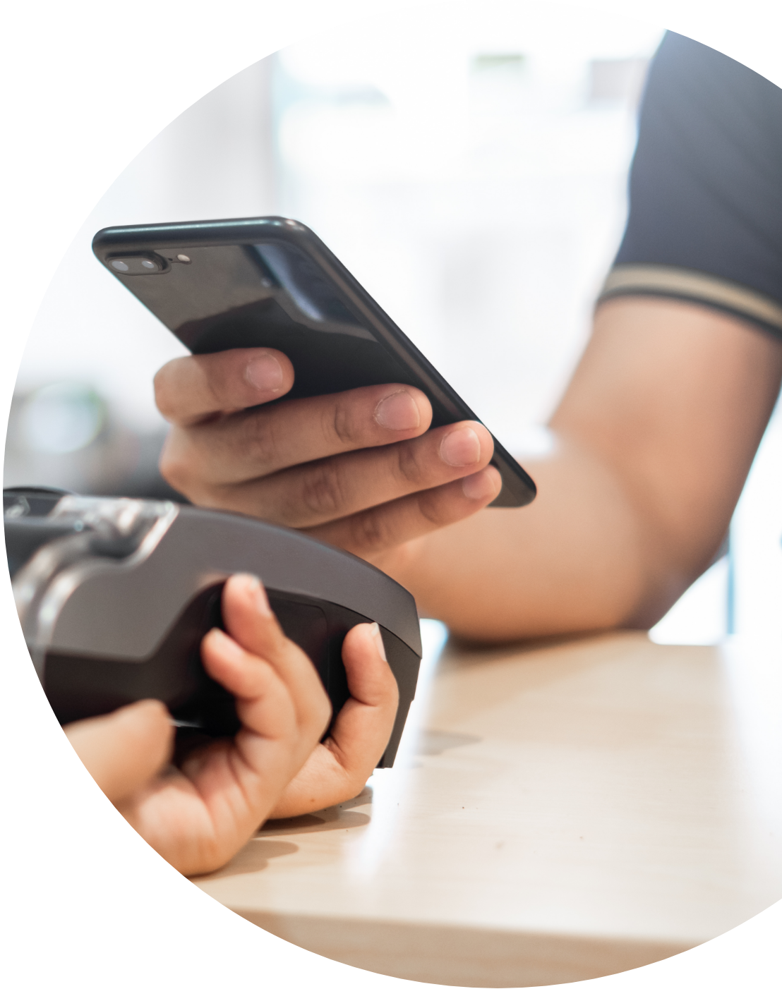 Customer using smartphone to complete contactless payment at retail checkout